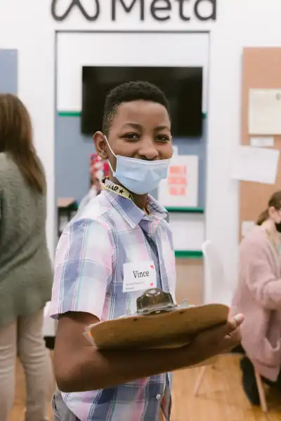 Student wearing a face mask in front of Meta's JA BizTown shop